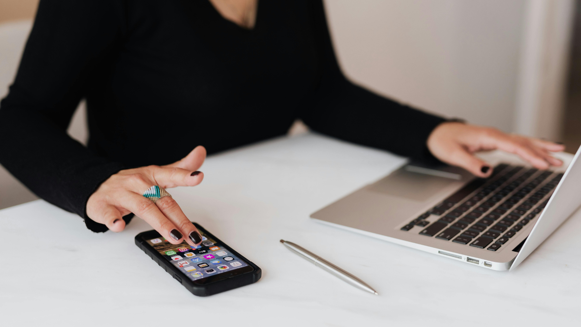 Photo d'illustration d'une femme sur son téléphone et son ordinateur.