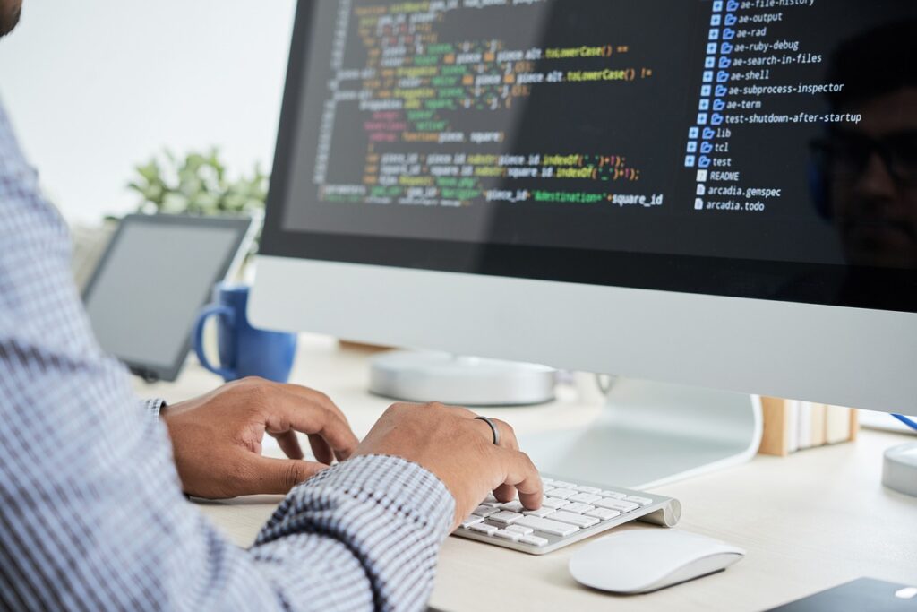 Un homme en train d'écrire sur son clavier d'ordinateur. 